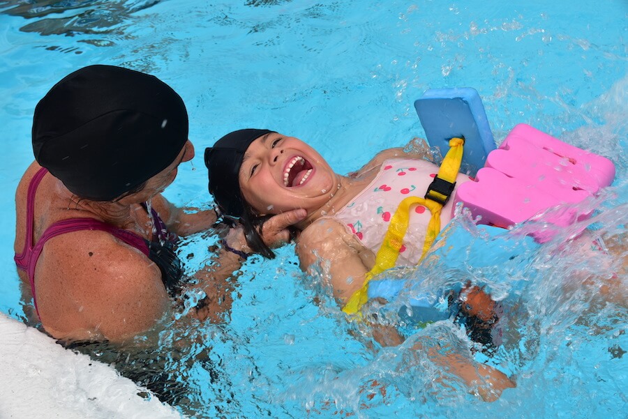 Young girl learning how to swim while having fun