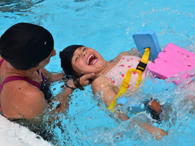 Young girl learning how to swim while having fun